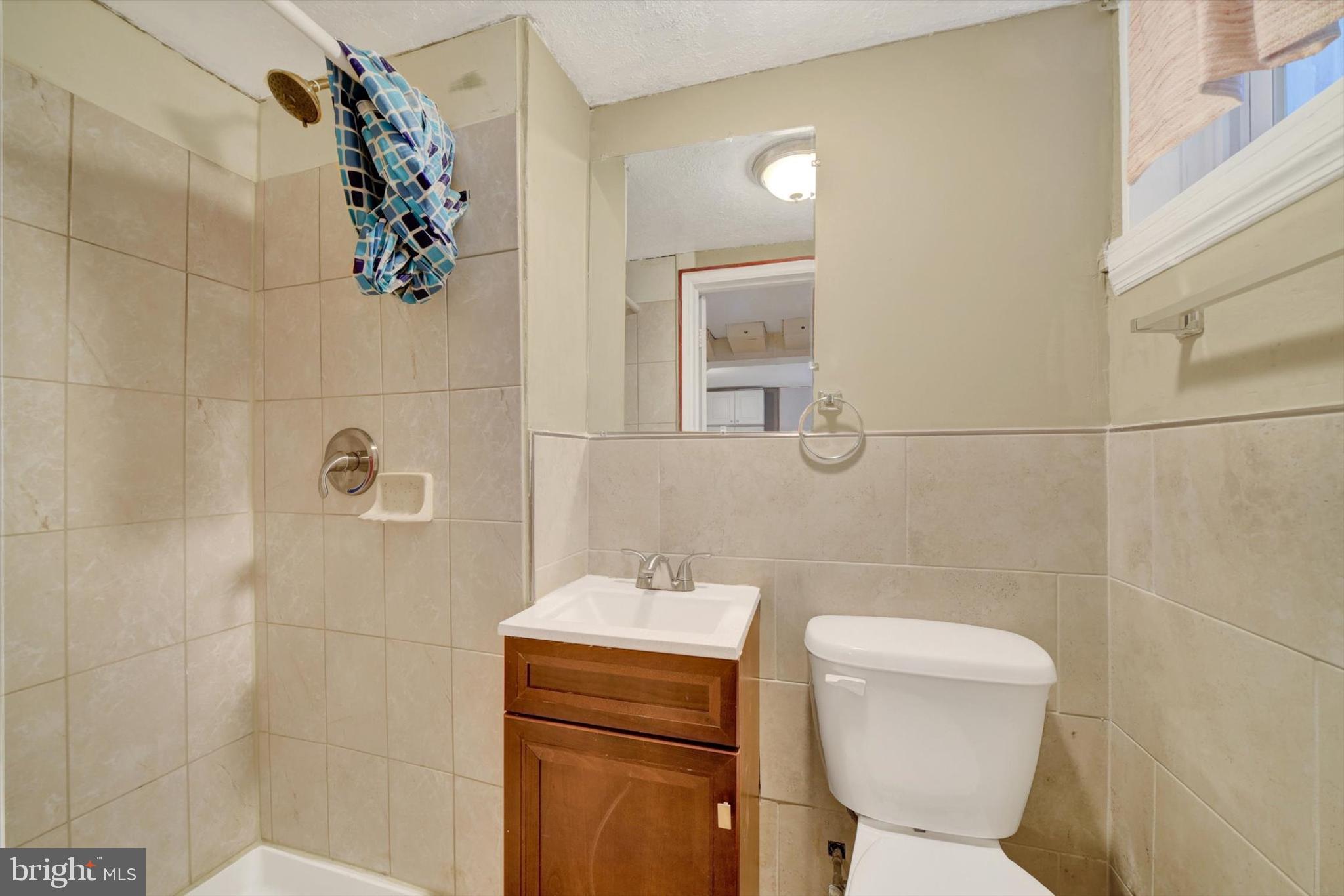 316 Lambeth Road Baltimore, MD 21228 - Photo 25 of 28 a bathroom with a toilet sink and mirror