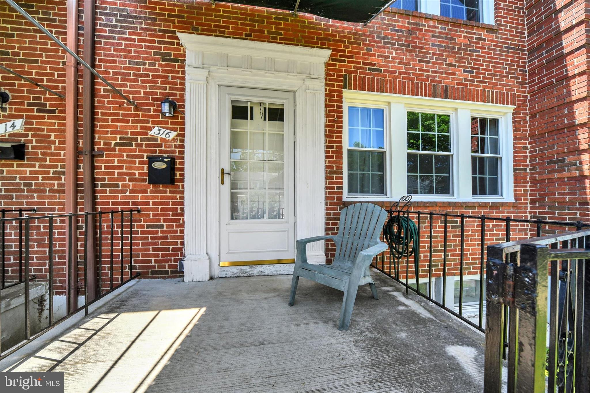 316 Lambeth Road Baltimore, MD 21228 - Photo 3 of 28 a view of a brick house with a bench