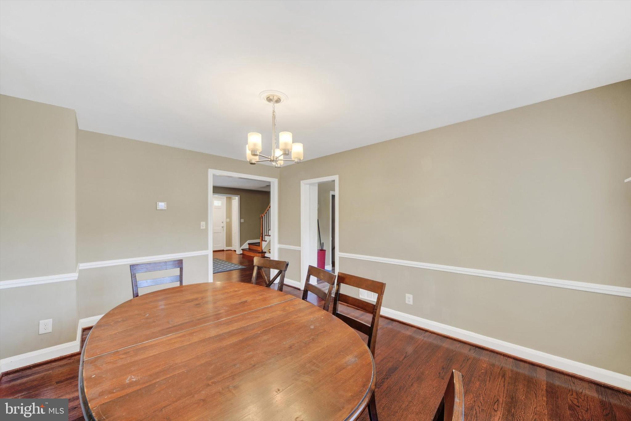 316 Lambeth Road Baltimore, MD 21228 - Photo 8 of 28 a spacious bedroom with a bed and a chandelier