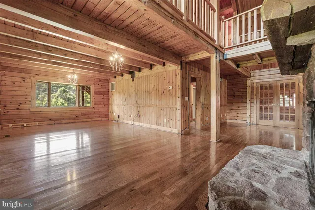 a view of a hallway with wooden floor and a living room