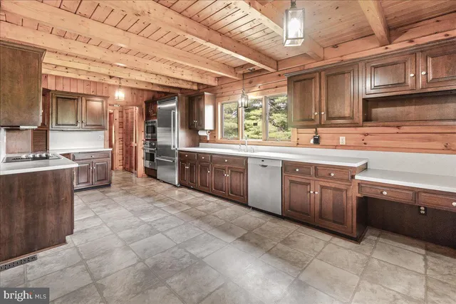 a large kitchen with stainless steel appliances granite countertop a stove sink and cabinets