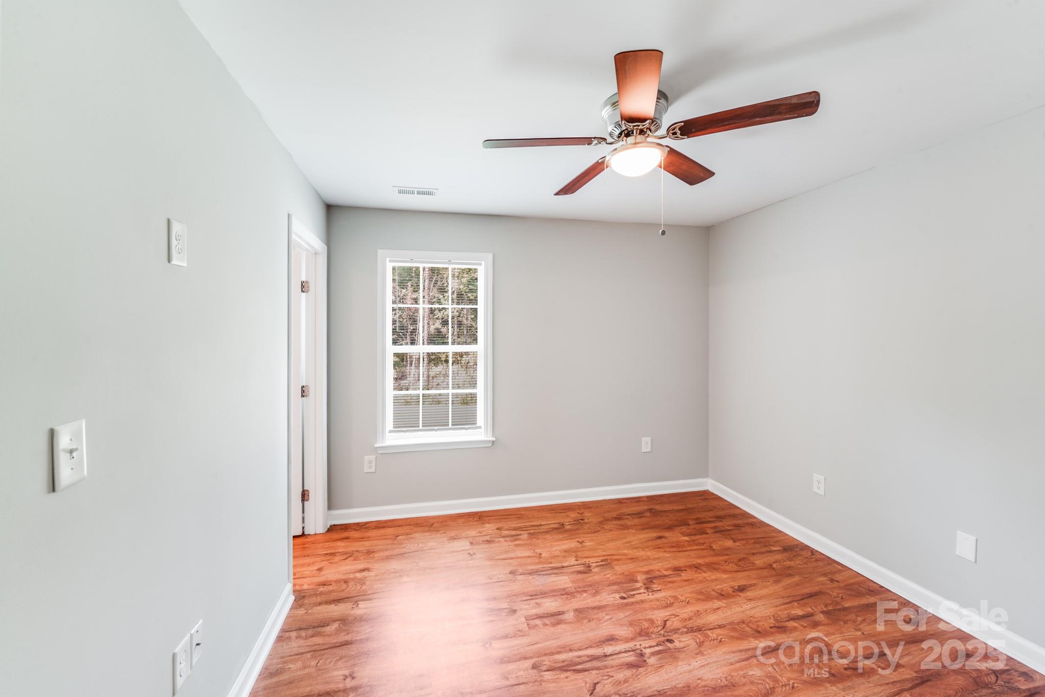 3134 Rainbow Ridge Drive Matthews, NC 28105 - Photo 15 of 20 an empty room with a window and ceiling fan