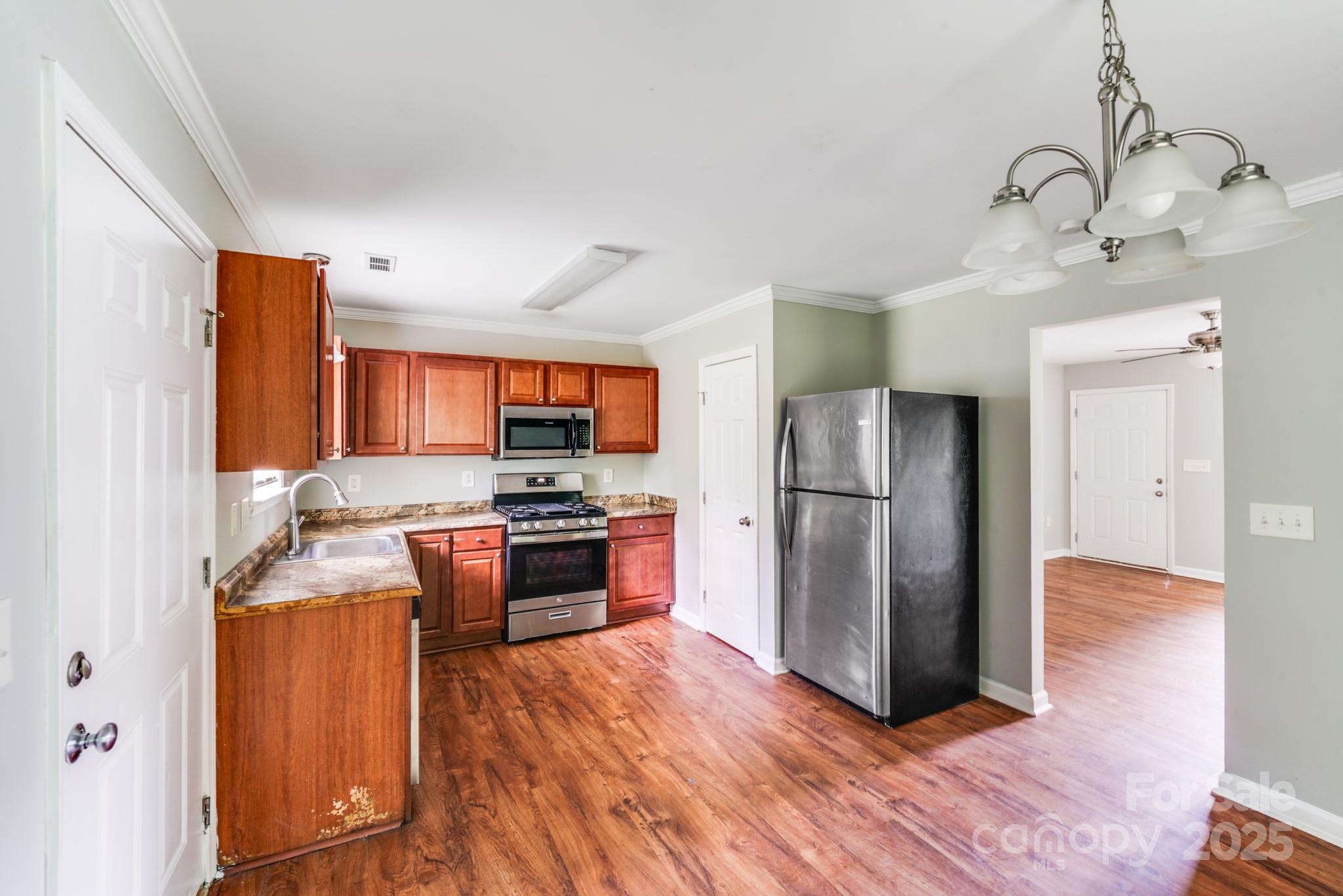 3134 Rainbow Ridge Drive Matthews, NC 28105 - Photo 9 of 20 a kitchen with stainless steel appliances granite countertop a refrigerator a sink dishwasher a stove with wooden floor and cabinets