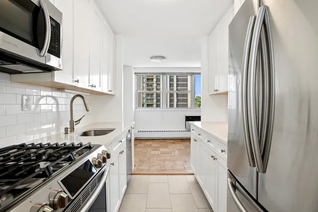 a kitchen with stainless steel appliances a stove a sink and a refrigerator