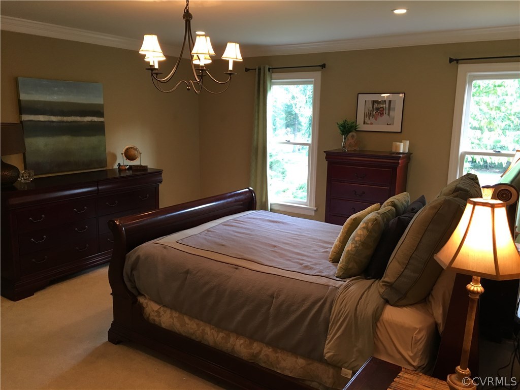 6007 Moss Creek Road Midlothian, VA 23112 - Photo 21 of 38 a bedroom with a bed and a chandelier