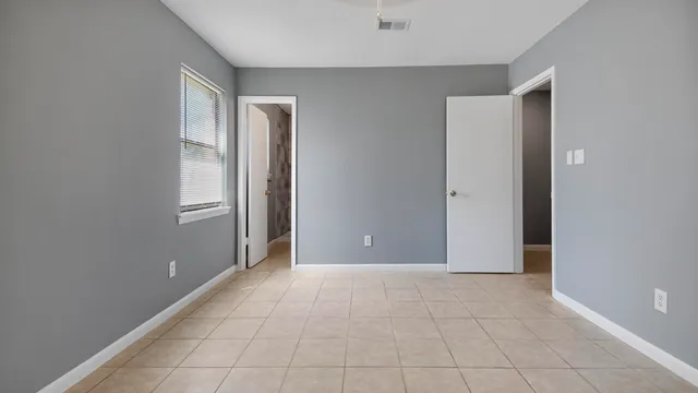 a view of an empty room with window and closet area