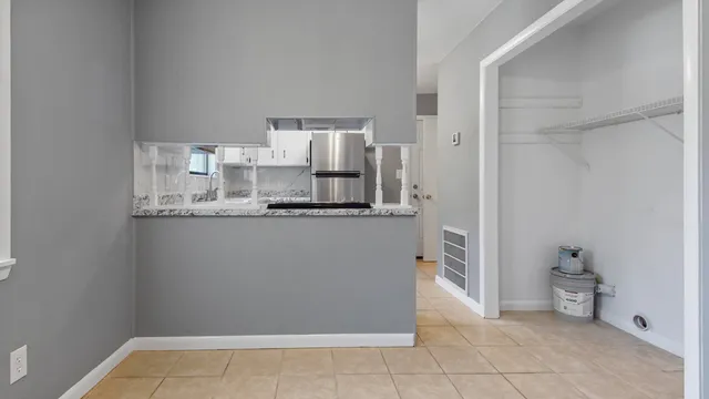 a view of a kitchen with refrigerator and cabinets