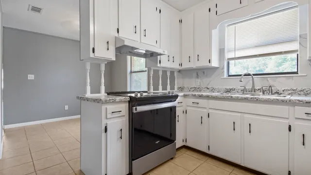 a kitchen with granite countertop a sink stainless steel appliances and cabinets