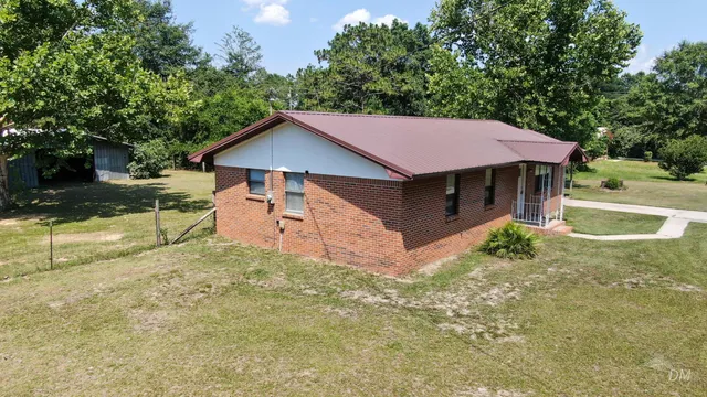 a small barn with a big yard and large trees