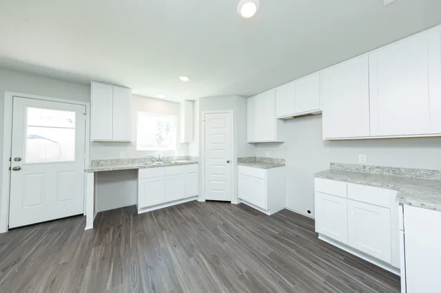 a kitchen with granite countertop white cabinets and white appliances