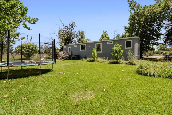 a view of a house with backyard and trees