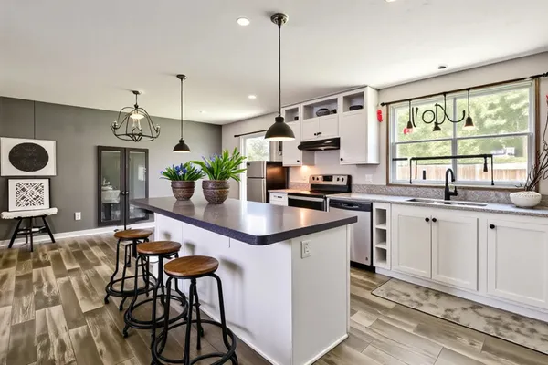 a kitchen with stainless steel appliances granite countertop a sink a stove a refrigerator and cabinets