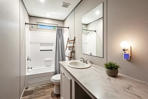 a bathroom with a granite countertop sink a toilet and shower