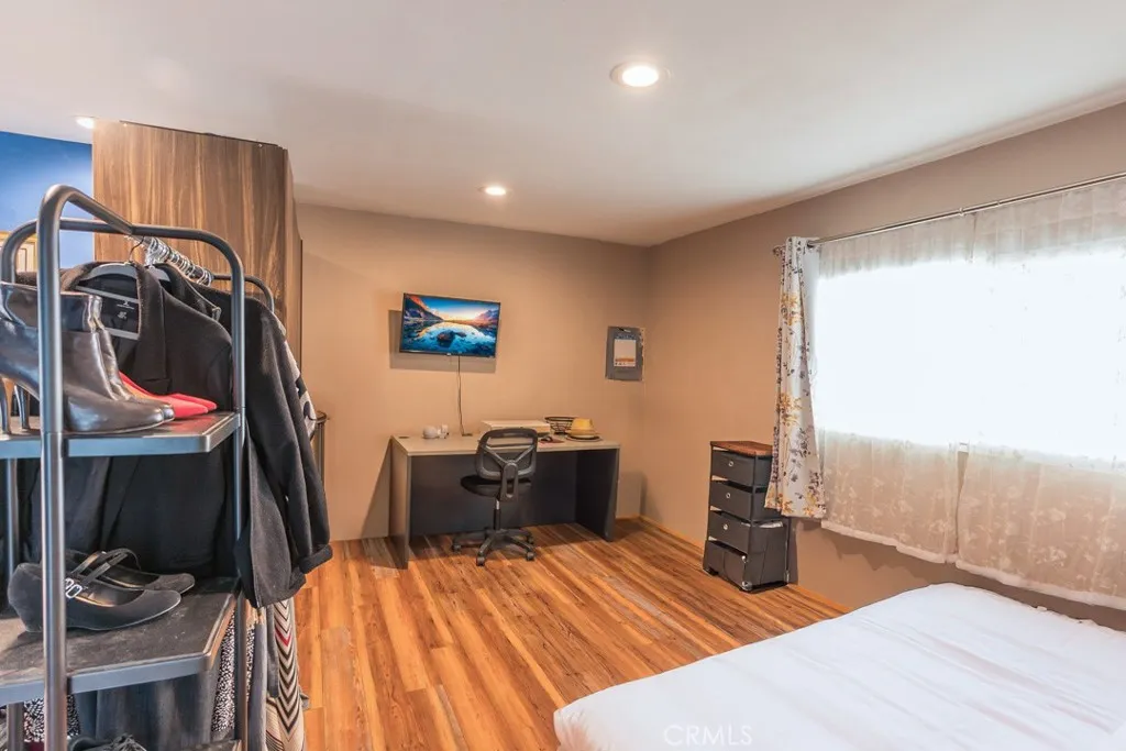 23500 The Old Road, Unit 35 Newhall, CA 91321 - Photo 20 of 43 a bedroom with a bed and wooden floor