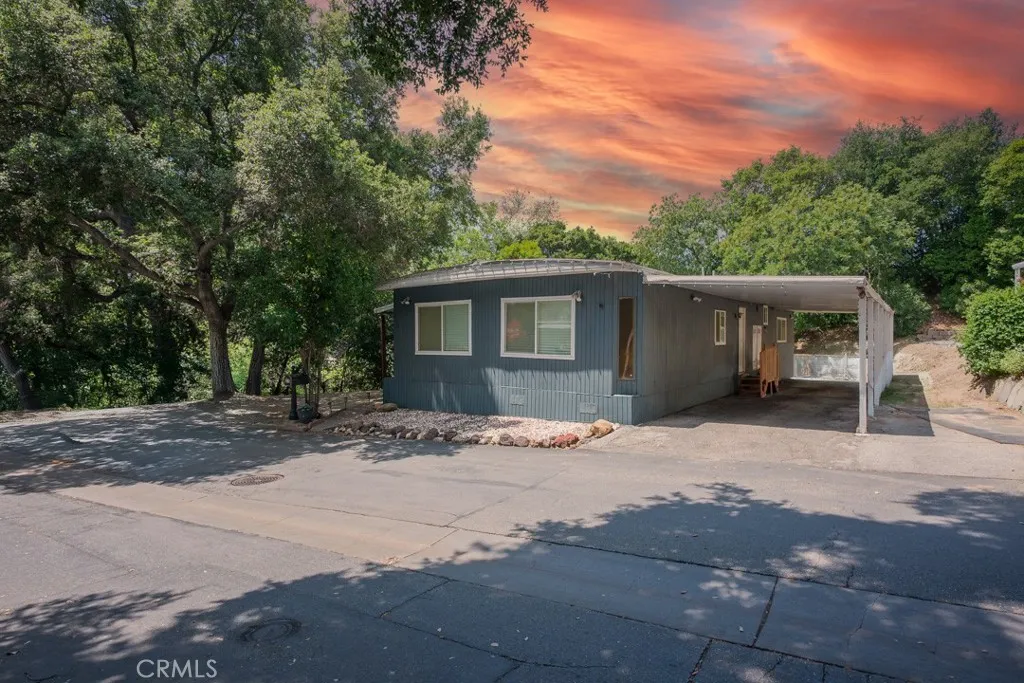23500 The Old Road, Unit 35 Newhall, CA 91321 - Photo 2 of 43 a front view of house with yard and trees around