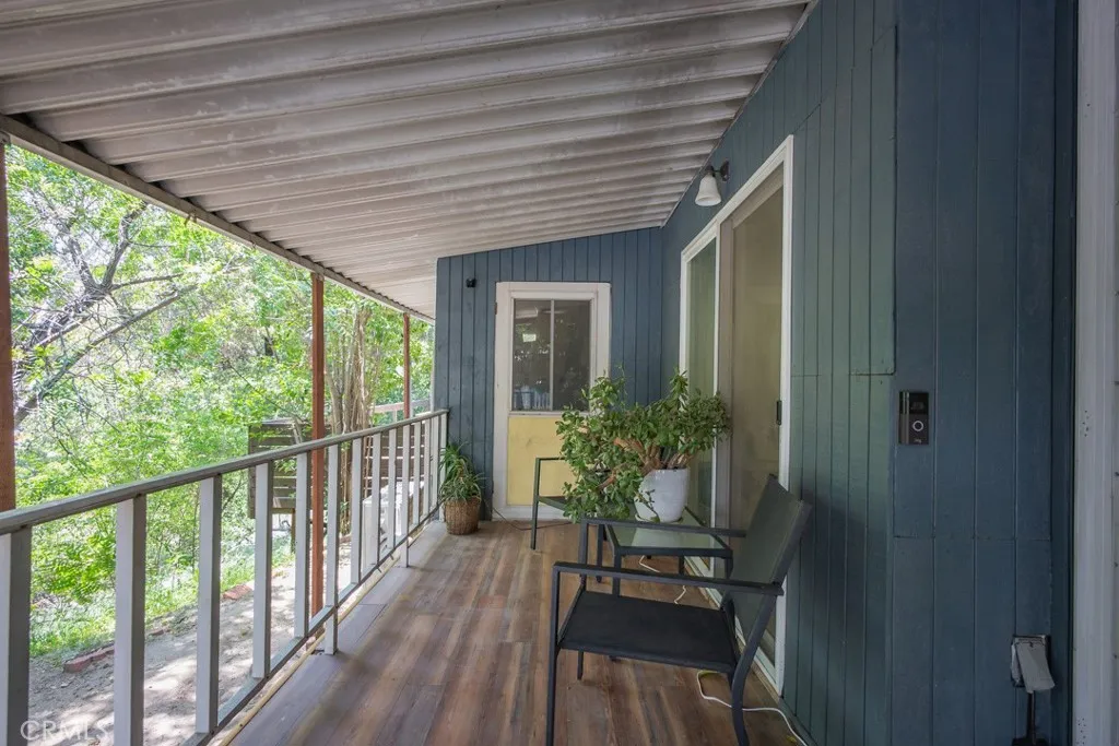 23500 The Old Road, Unit 35 Newhall, CA 91321 - Photo 26 of 43 a porch with chairs and wooden floor