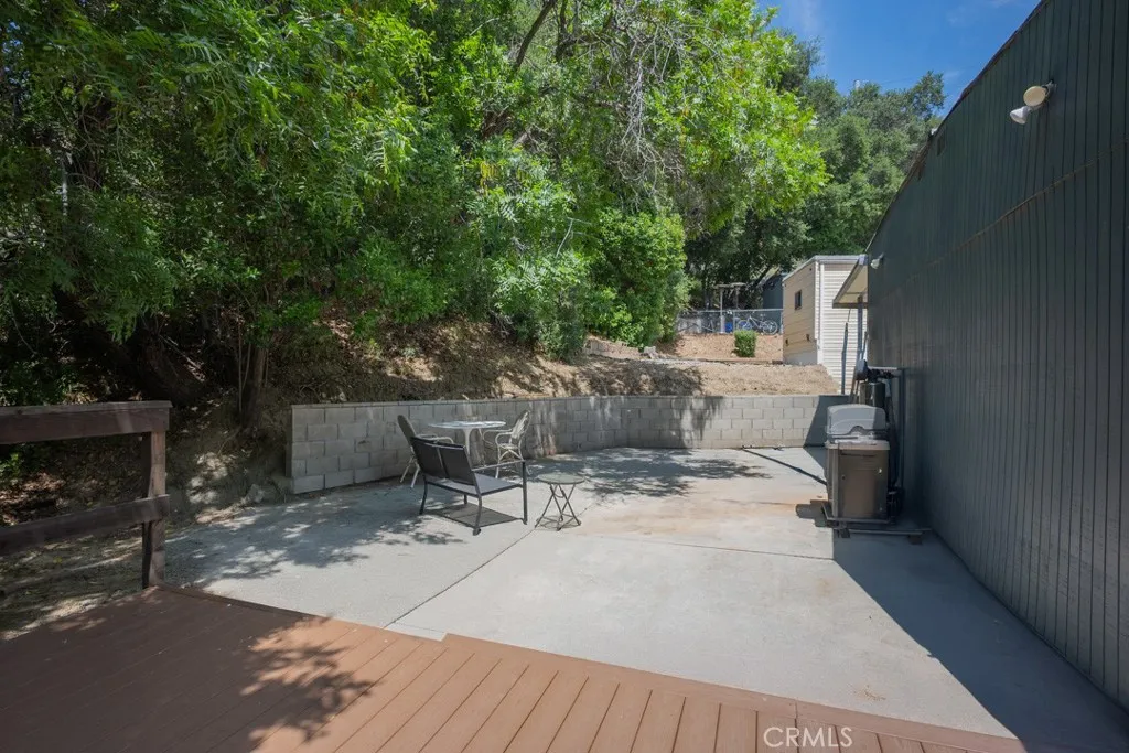 23500 The Old Road, Unit 35 Newhall, CA 91321 - Photo 35 of 43 a view of backyard with a table and chairs with wooden fence and plants