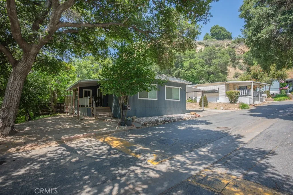 23500 The Old Road, Unit 35 Newhall, CA 91321 - Photo 38 of 43 a view of a house with a yard and large tree