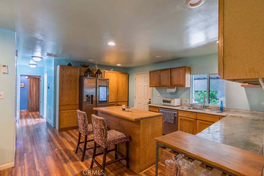 23500 The Old Road, Unit 35 Newhall, CA 91321 - Photo 7 of 43 a kitchen with stainless steel appliances granite countertop counter space a sink refrigerator and cabinets
