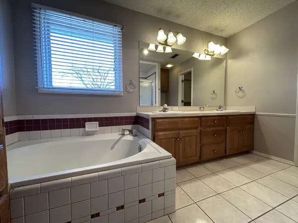 a spacious bathroom with a tub sink and a mirror