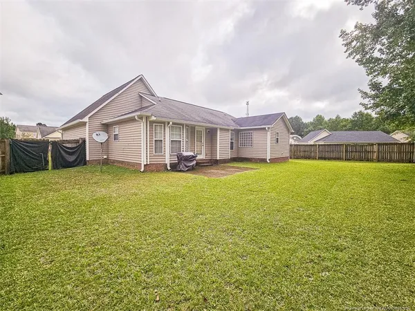 a view of a house with a big yard and large trees