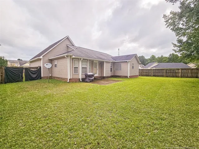 a view of a house with a big yard and large trees