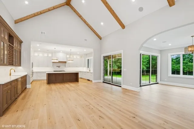 a large white building with kitchen view and wooden floor