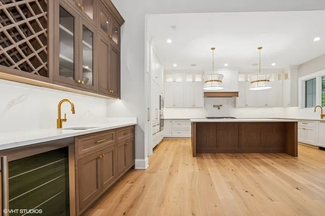 a large kitchen with stainless steel appliances kitchen island granite countertop a large counter top and wooden floors