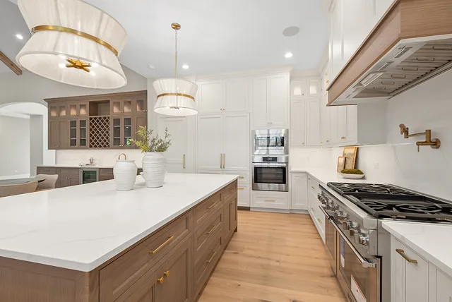 a kitchen with stainless steel appliances granite countertop a sink stove and cabinets