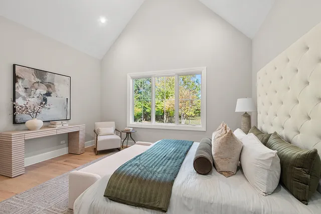 a bedroom with a bed and a large window