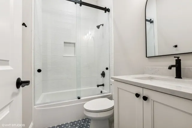 a bathroom with a granite countertop sink a toilet and shower
