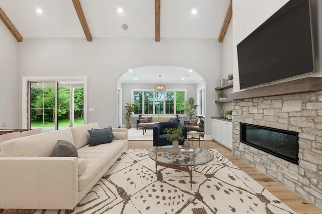 a living room with furniture a large window and a fireplace