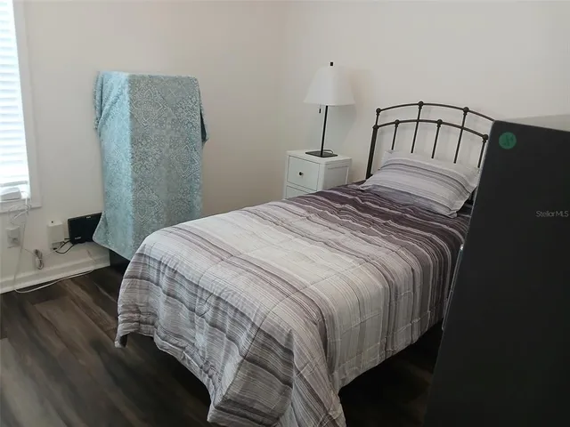 a bedroom with a bed and wooden floor