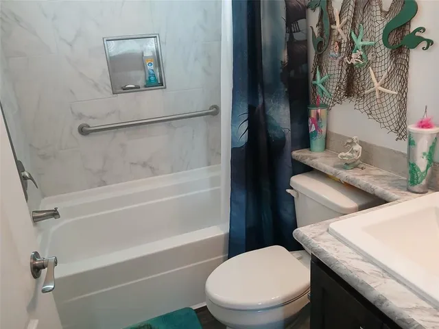 a white toilet sitting next to a bathroom sink and tub