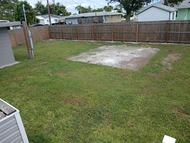a view of a backyard with a small cabin and wooden fence