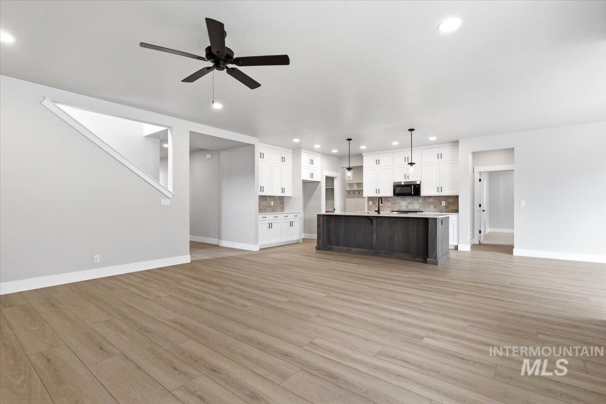4317 Tropic Way Caldwell, ID 83607 - Photo 7 of 47 Open-concept living space featuring engineered wood-finish flooring, vaulted ceilings with ceiling fan, and abundant recessed lighting