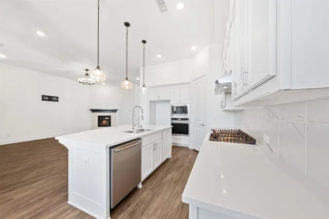 a kitchen with a sink a stove and chairs