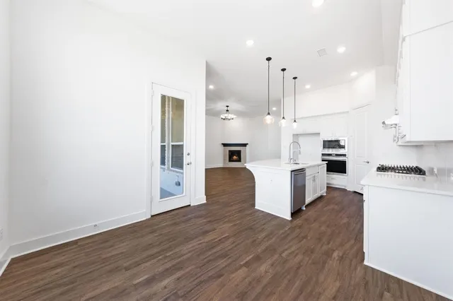 a kitchen with kitchen island white cabinets and stainless steel appliances