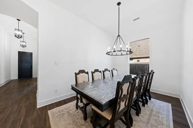 a view of a dining room with a table and chairs