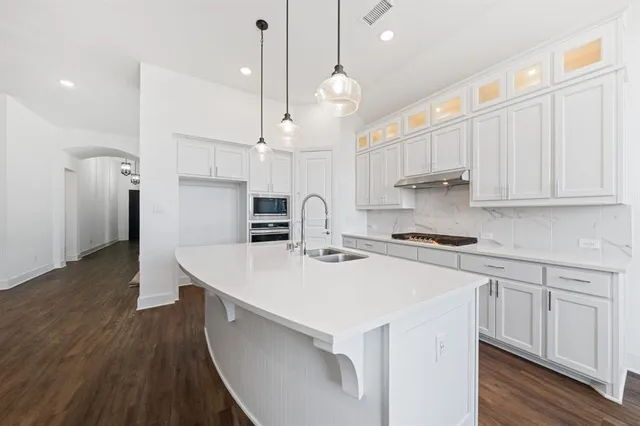 a kitchen with kitchen island a white cabinets and wooden floor