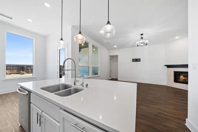 a large kitchen with kitchen island a sink and a stove with wooden floor