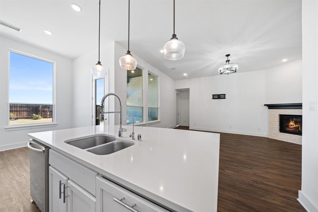 1723 Cypress Gap Trail Mansfield, TX 76063 - Photo 10 of 29 a large kitchen with kitchen island a sink and a stove with wooden floor