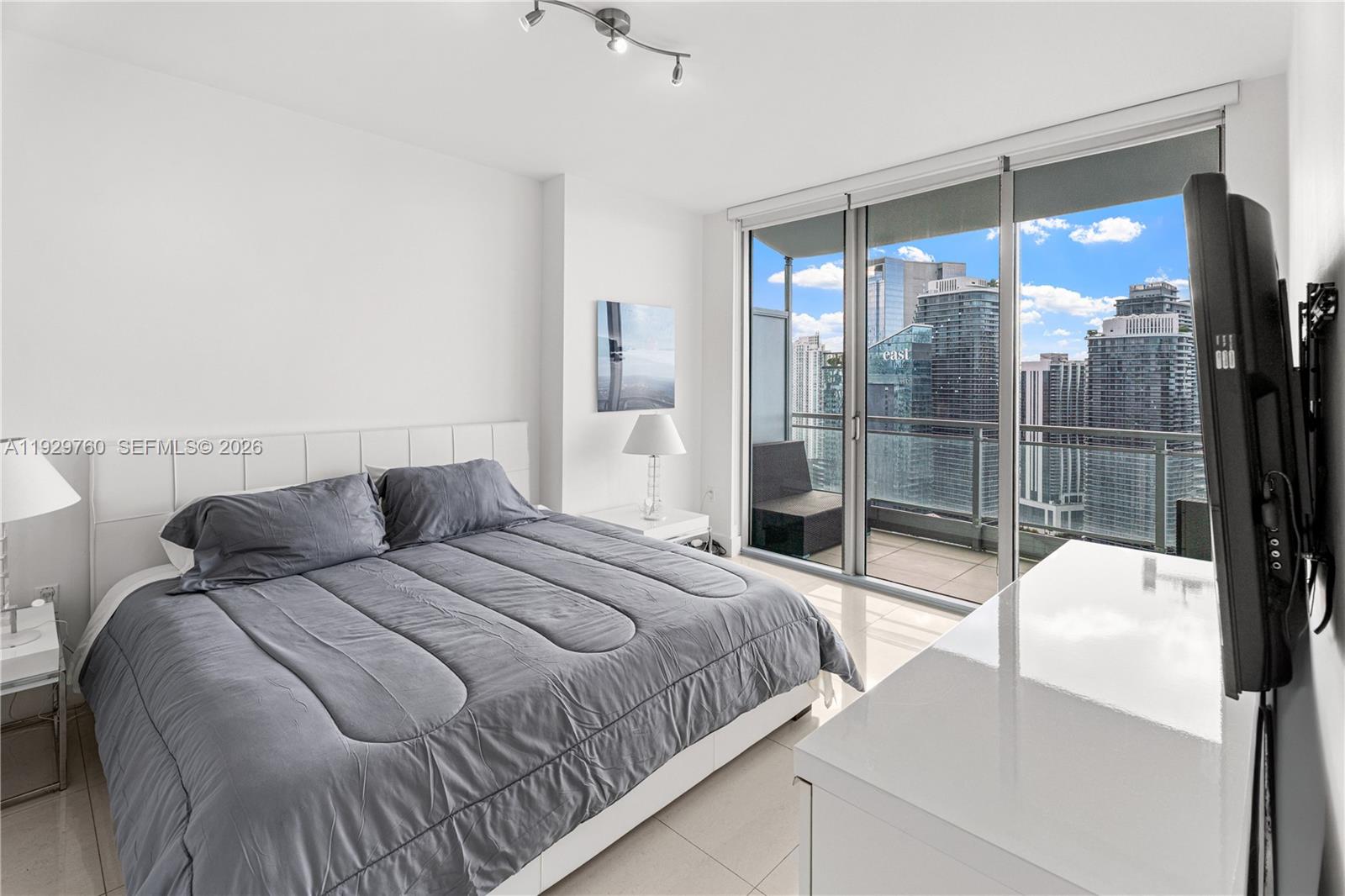 92 Southwest 3rd Street, Unit 4704 Miami, FL 33130 - Photo 11 of 34 a bedroom with a bed and a glass door