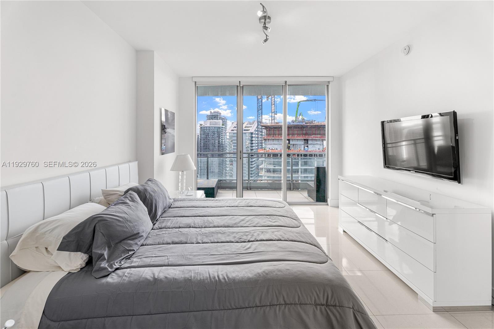 92 Southwest 3rd Street, Unit 4704 Miami, FL 33130 - Photo 12 of 34 a spacious bedroom with a large bed a flat tv screen and a couch