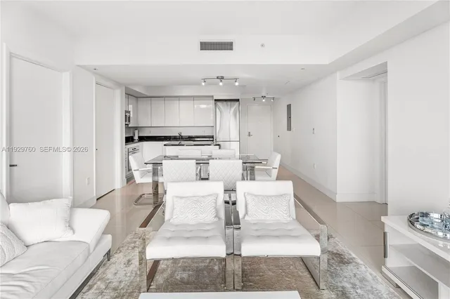 a living room with furniture and a view of kitchen