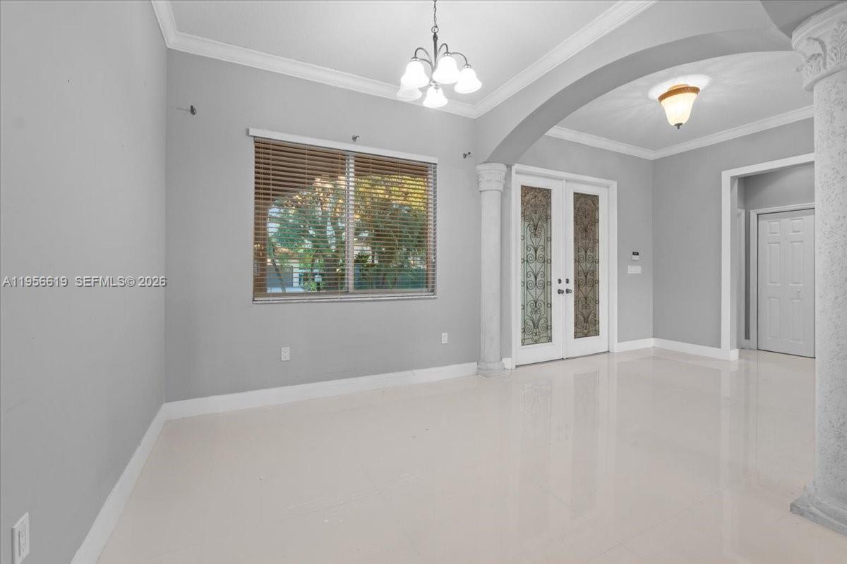 16640 Northwest 86th Court Miami Lakes, FL 33016 - Photo 11 of 23 en empty room with windows and chandelier