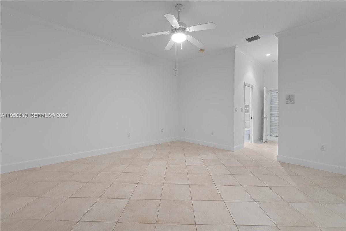 16640 Northwest 86th Court Miami Lakes, FL 33016 - Photo 16 of 23 en empty room with white walls and chandelier fan