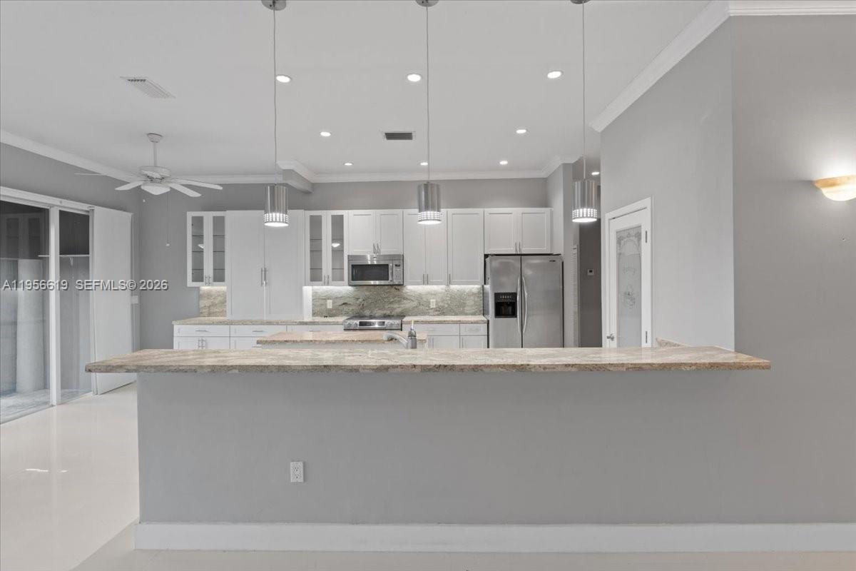 16640 Northwest 86th Court Miami Lakes, FL 33016 - Photo 5 of 23 a large white kitchen with a large window