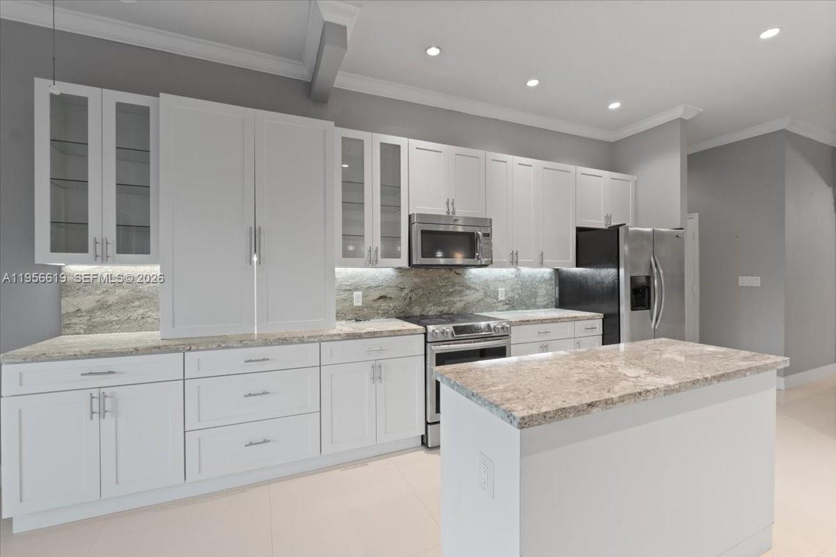 16640 Northwest 86th Court Miami Lakes, FL 33016 - Photo 6 of 23 a kitchen with white cabinets and stainless steel appliances