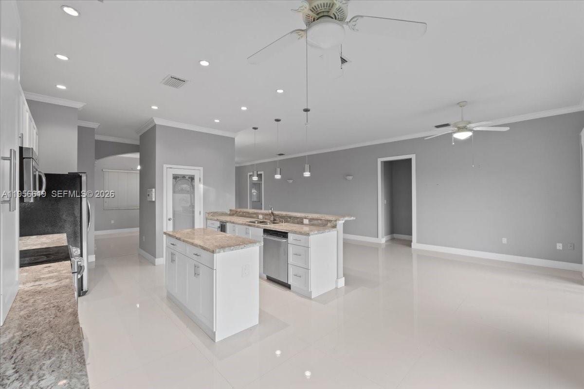 16640 Northwest 86th Court Miami Lakes, FL 33016 - Photo 7 of 23 a large white kitchen with a large counter top appliances and cabinets